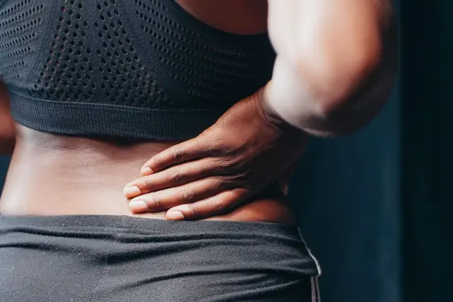 A person holding their lower back in pain